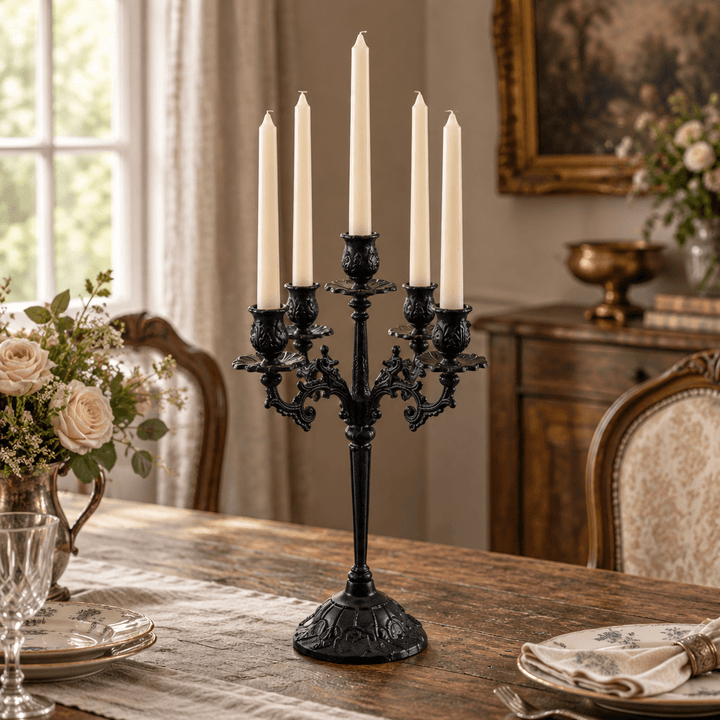 Ornate cast iron candelabra with ivory taper candles on a vintage dining table