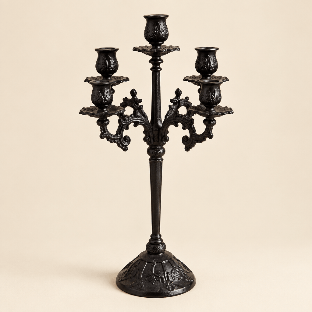 Ornate black cast iron candelabra with five candle holders against an ivory studio background