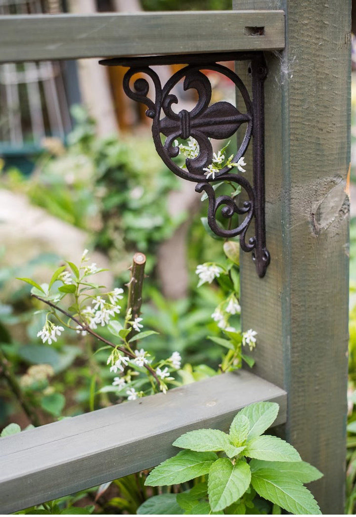 Fleur-de-Lis Cast Iron Shelf Bracket installed on an outdoor shelf