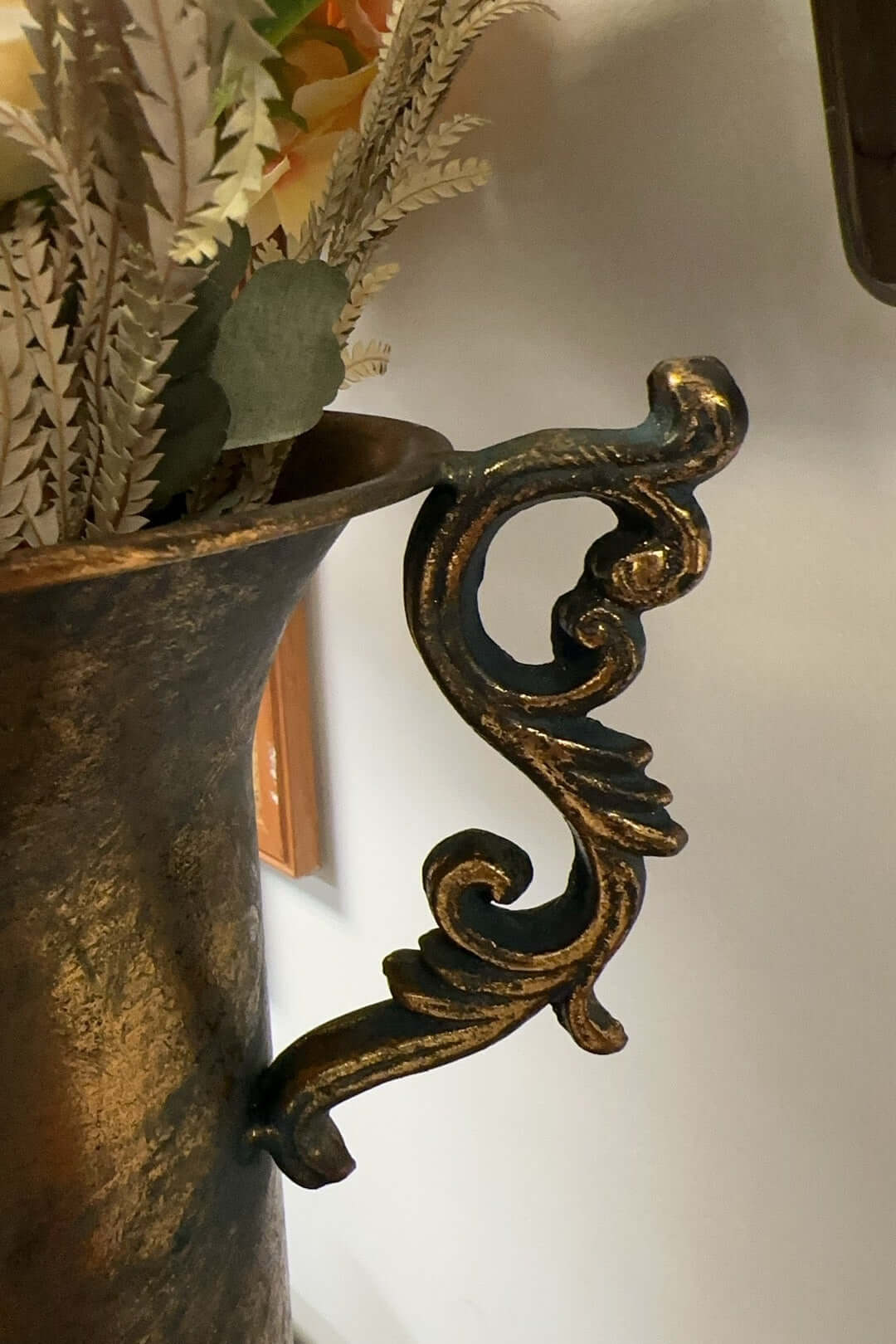 French country antique gold urn vase with ornate handles and floral medallion detail, evoking timeless elegance and charm.