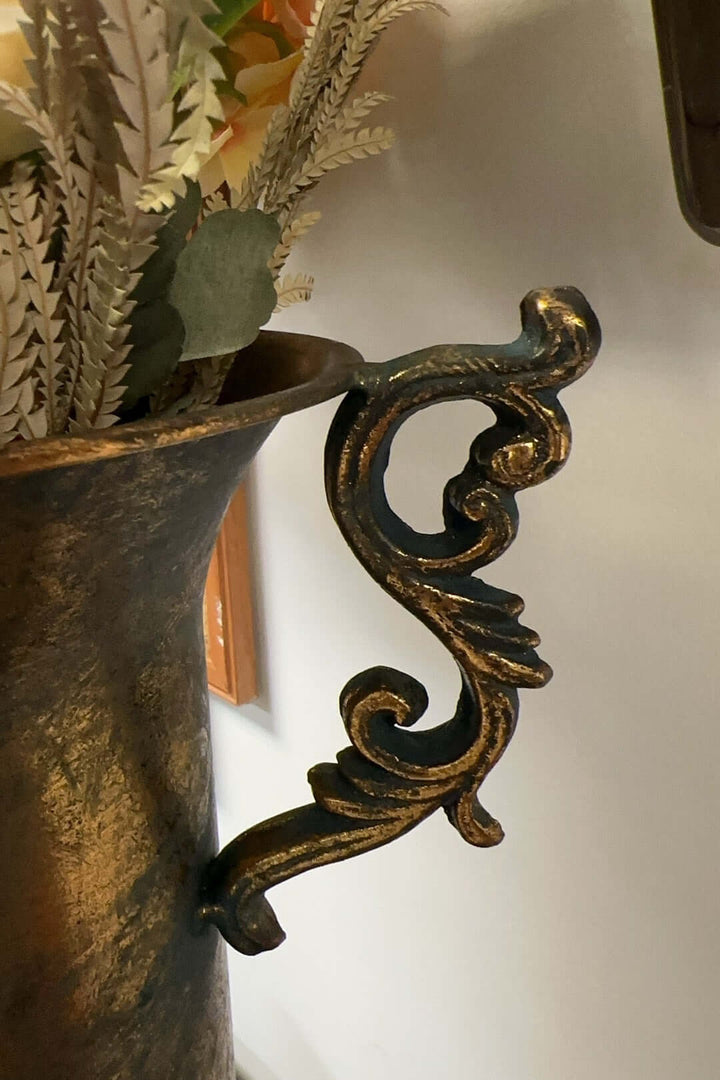 French country antique gold urn vase with ornate handles and floral medallion detail, evoking timeless elegance and charm.