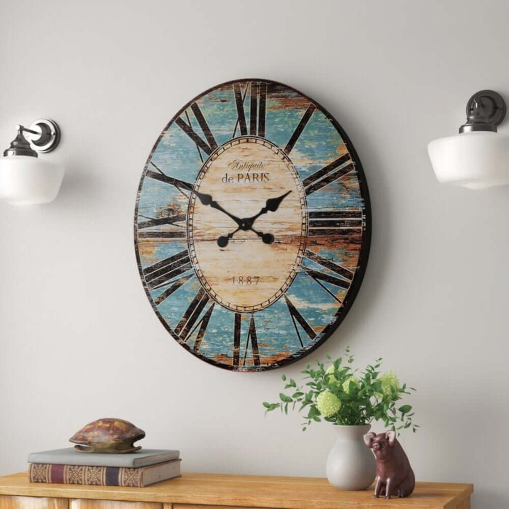 French Country Turquoise Distressed Paris Wall Clock with Roman numerals, hanging between wall sconces, adding vintage charm.