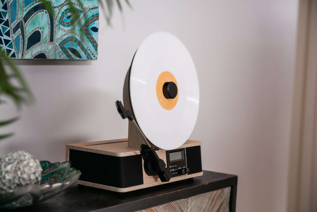 Record player with a large vinyl record on a wooden stand against a neutral wall.