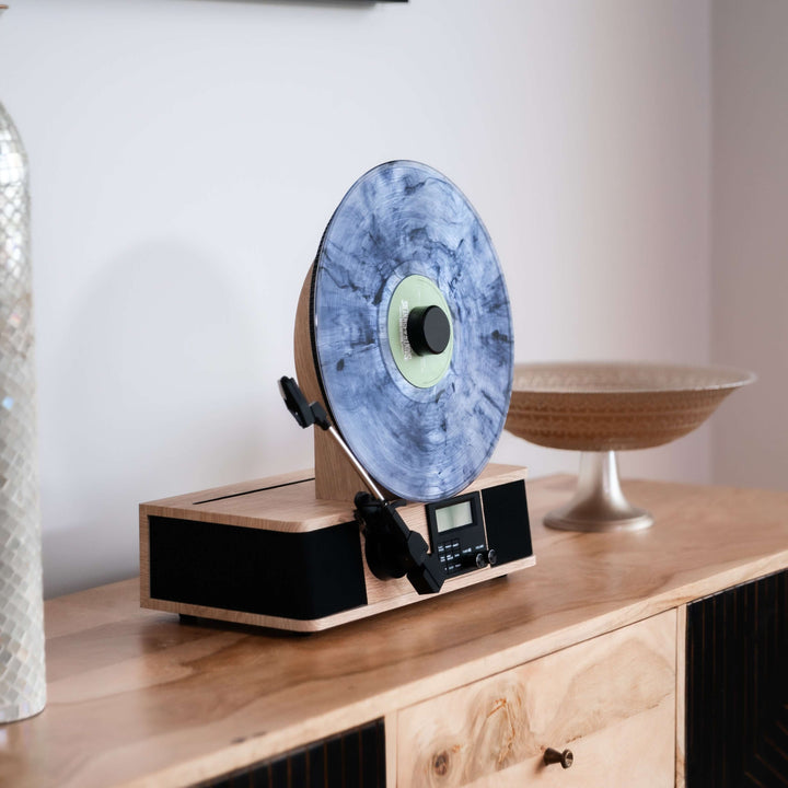 Turntable with a blue vinyl record on a wooden console table.