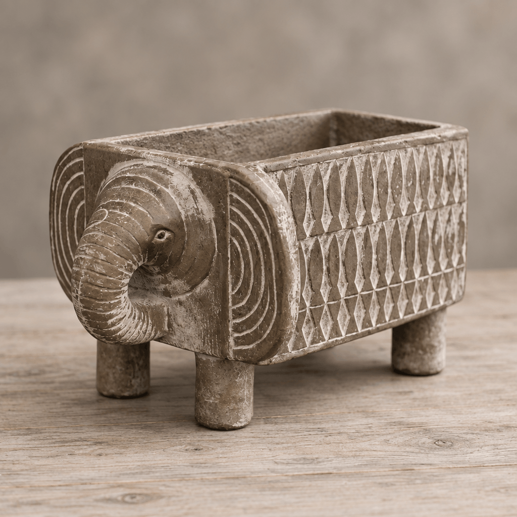 Detail of an elephant planter's curled trunk, concentric ear markings, and pale geometric side pattern