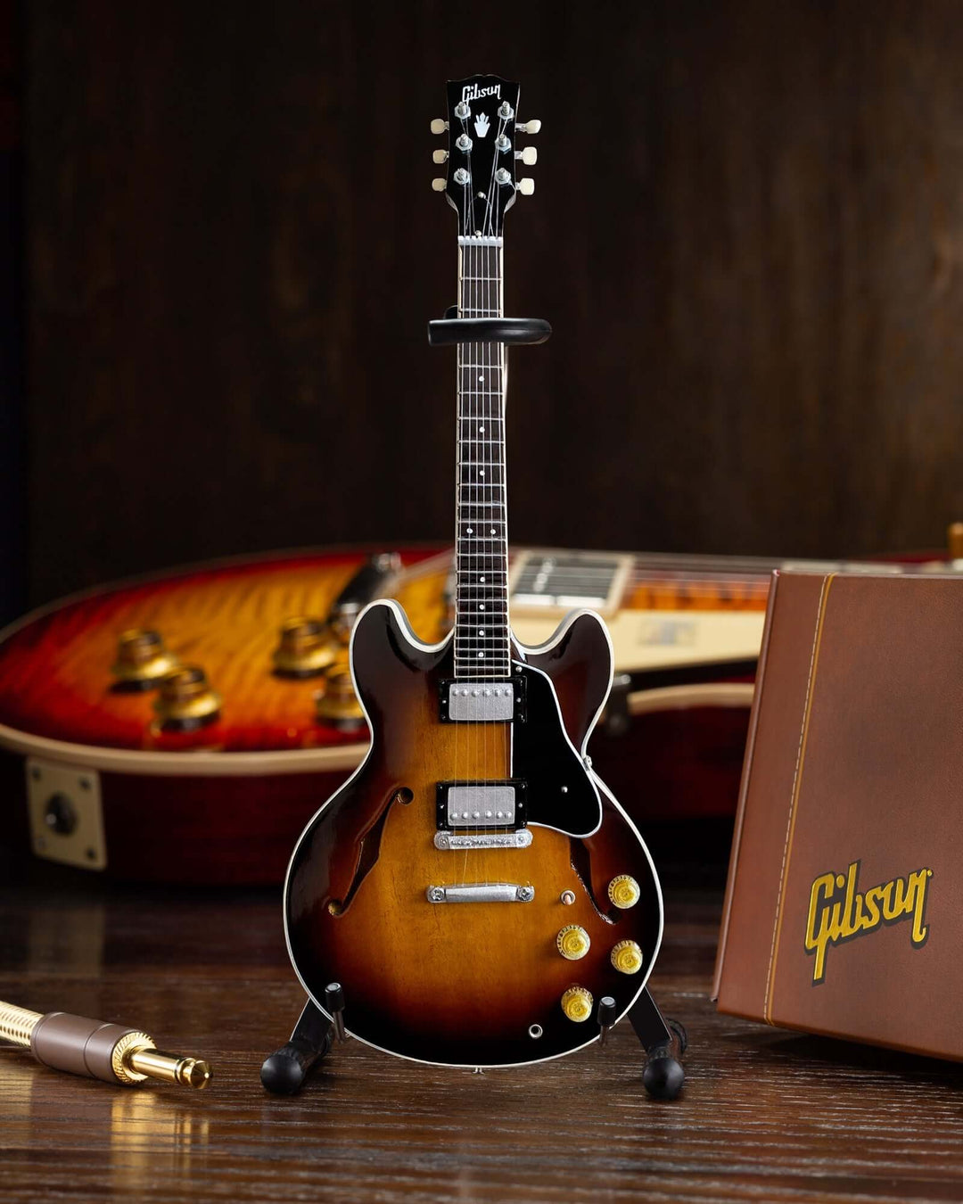 Gibson ES-335 Vintage Sunburst Mini Guitar Replica displayed with elegant wooden background