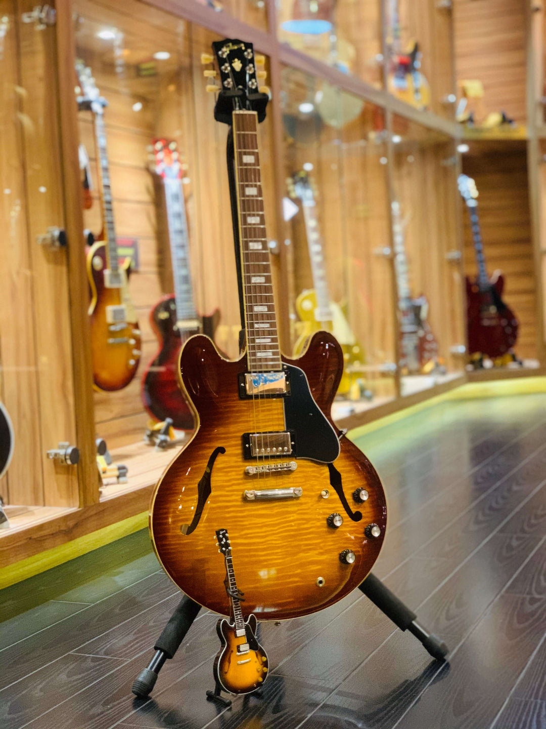 Gibson ES-335 Vintage Sunburst Mini Guitar Replica on display with other guitars in background