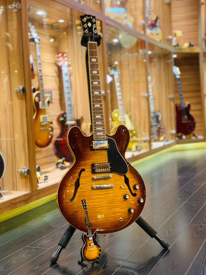 Gibson ES-335 Vintage Sunburst Mini Guitar Replica on display with other guitars in background