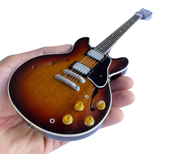 Hand holding a Gibson ES-335 Vintage Sunburst Mini Guitar Replica
