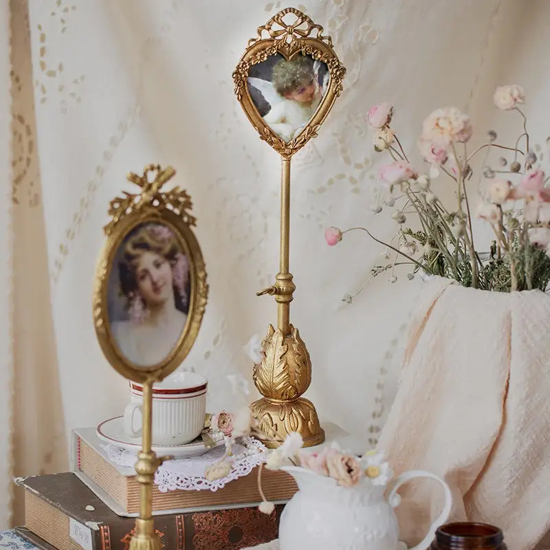 Tall oval pedestal photo frame displayed beside books, teacups, and pink blossoms