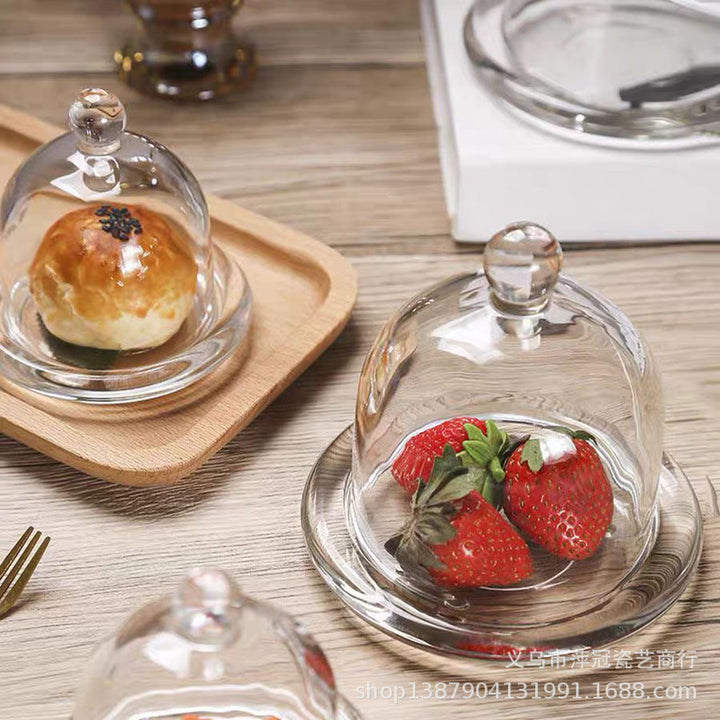 Clear glass cloche with round finial displayed on a tabletop