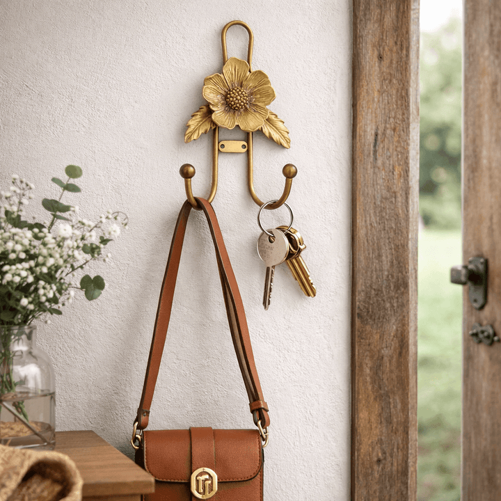 Layered gold flower wall hook holding a leather handbag and keys