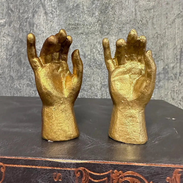 Close view of the two symbolic hand gestures in aged gold leaf