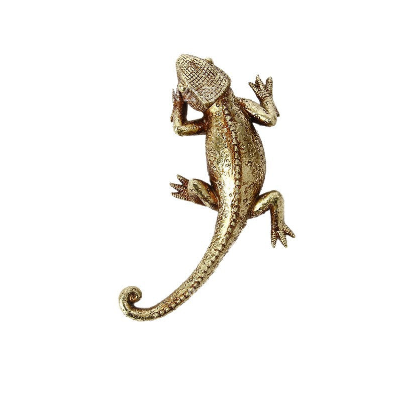 Full overhead view of gold-tone lizard showing curled tail and sculpted scales