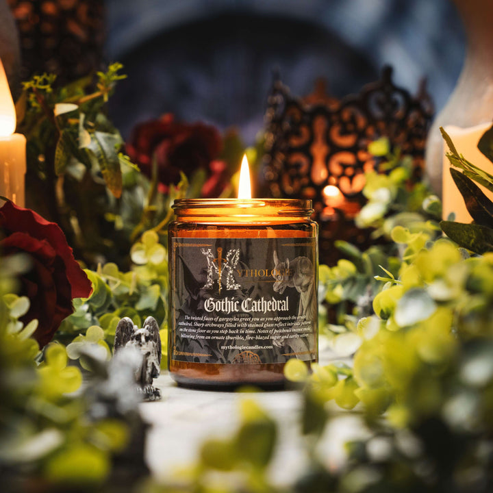 Gothic Cathedral Candle with lit flame surrounded by greenery and ornate decor for a medieval atmosphere