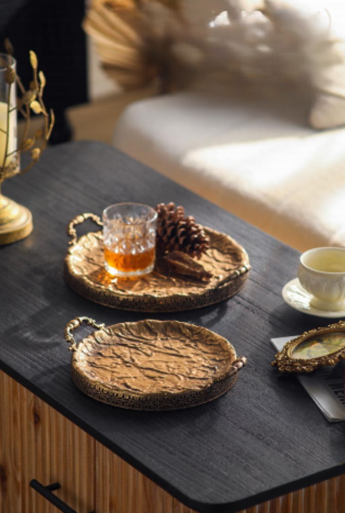 Hammered Antique Gold Round Serving Trays styled on a dark tabletop