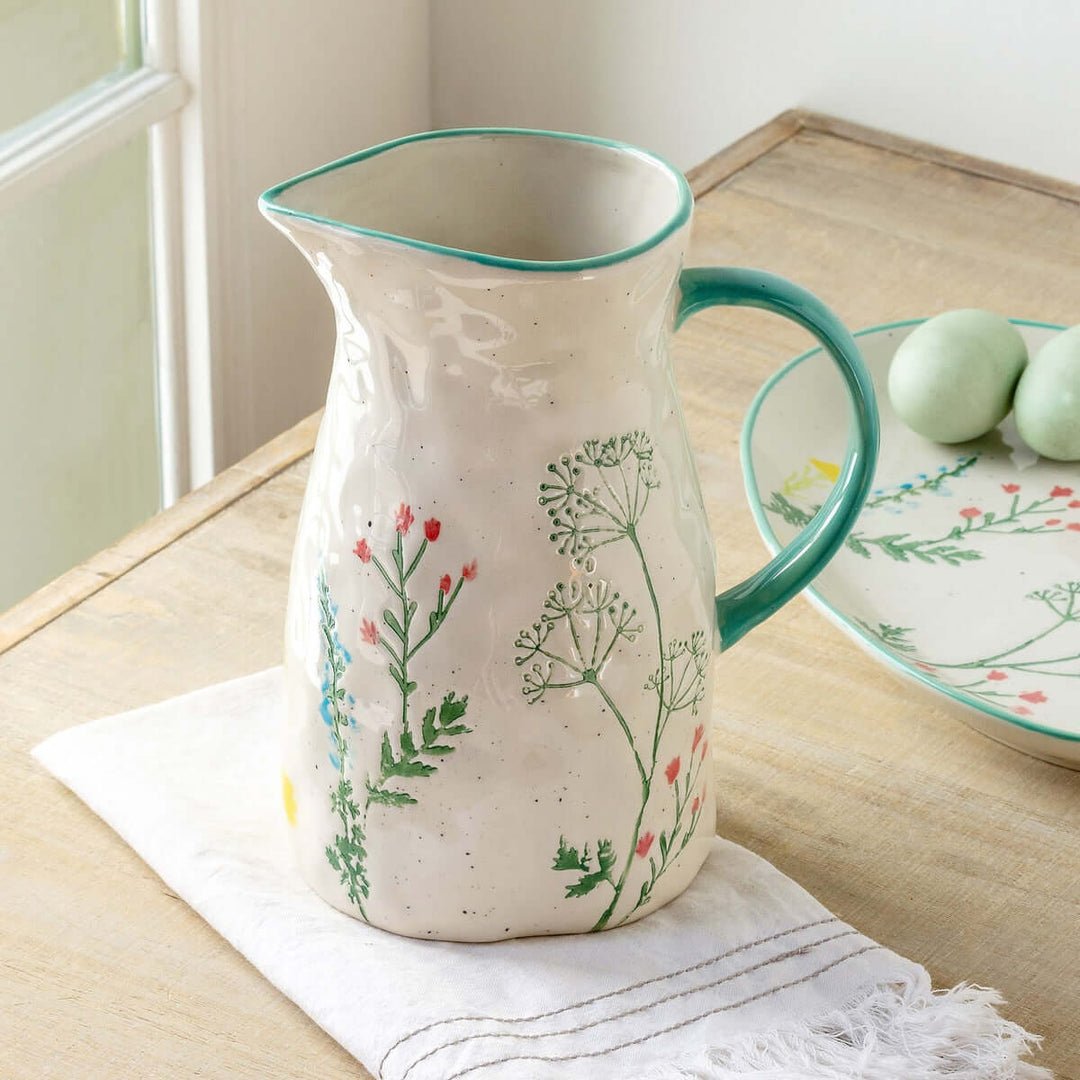 Hand-Painted Ceramic Wildflower Pitcher with delicate pastel floral design on wooden table