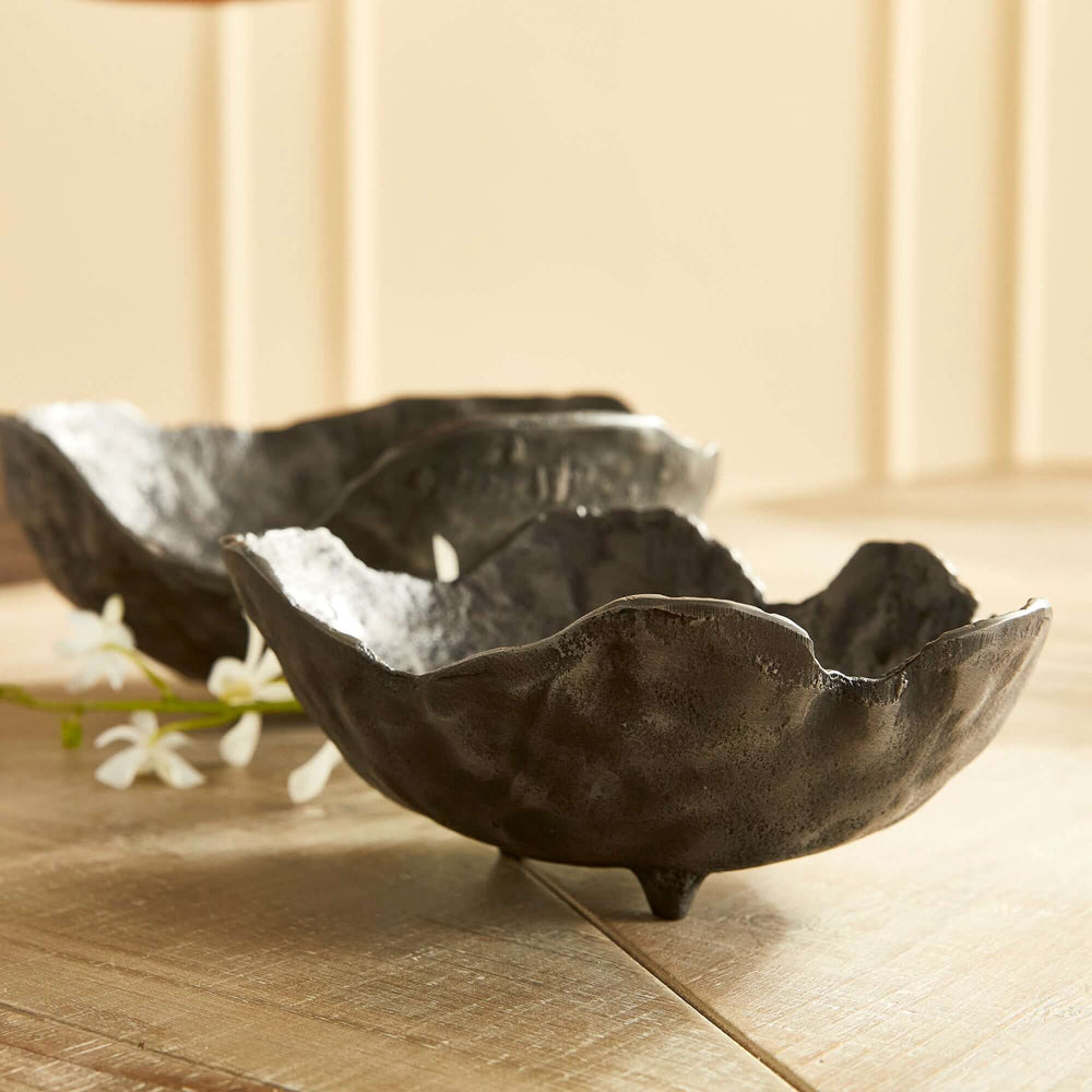 Hand-sculpted bronze decorative bowls set, showcasing vintage charm and artisan craftsmanship with textured surfaces on a wooden table.