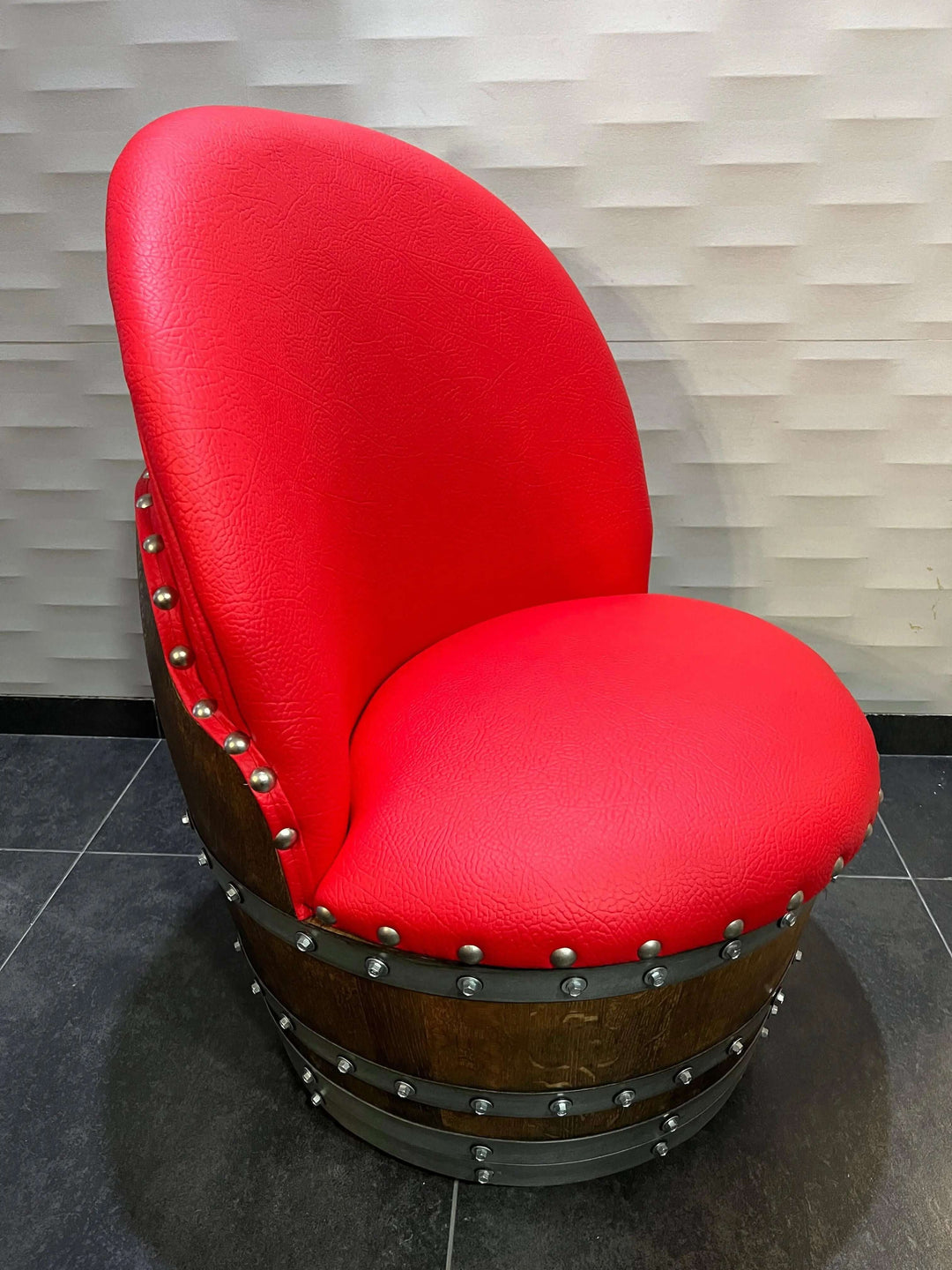 Red cushioned chair made from vintage oak barrel, part of the Handcrafted Vintage Oak Barrel Coffee Table and Chairs set.