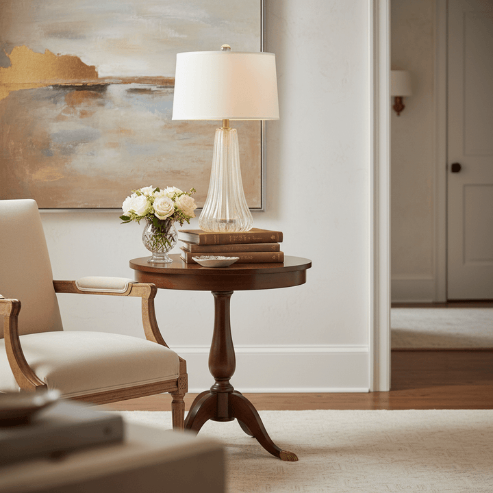 Wooden side table with lamp, books, and flowers in a living room setting.
