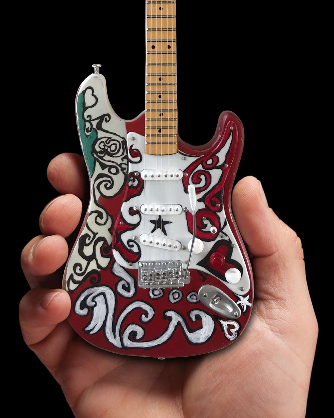 Hand holding Jimi Hendrix Fender Stratocaster Mini Guitar Replica showcasing intricate design.