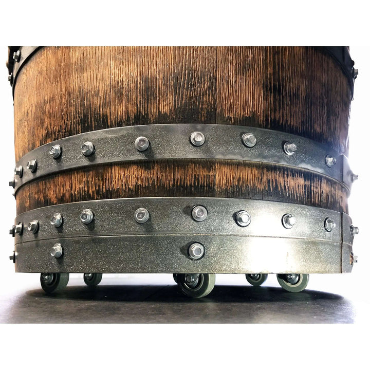Close-up of a Handcrafted Vintage Oak Barrel Coffee Table and Chairs base with metal accents and wheels.