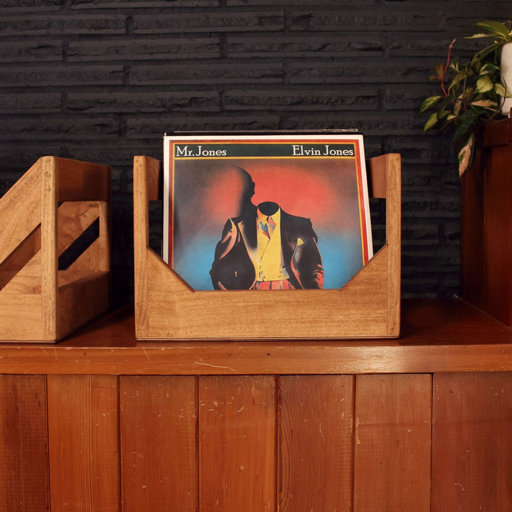 Handmade Wooden Vinyl Record Storage Crate on a wooden shelf holding LPs with a black brick background