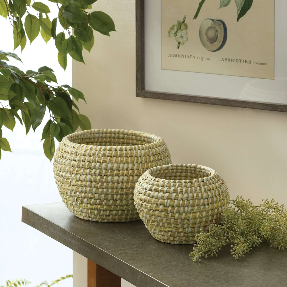Handwoven rivergrass fruit bowls in two sizes, showcasing rustic charm and natural textures on a table.