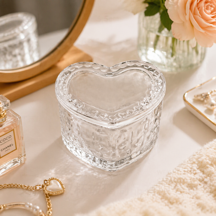 Heart-shaped glass trinket box styled on a vanity