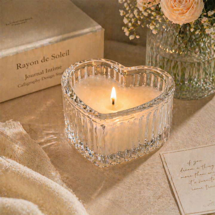 Heart-shaped clear glass box styled with a glowing candle