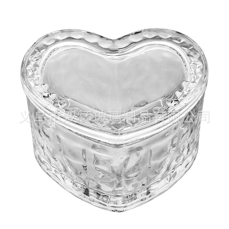 Faceted heart-shaped glass trinket box on a white background