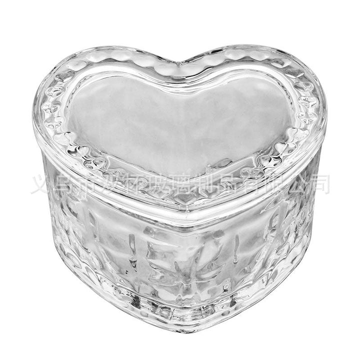 Faceted heart-shaped glass trinket box on a white background