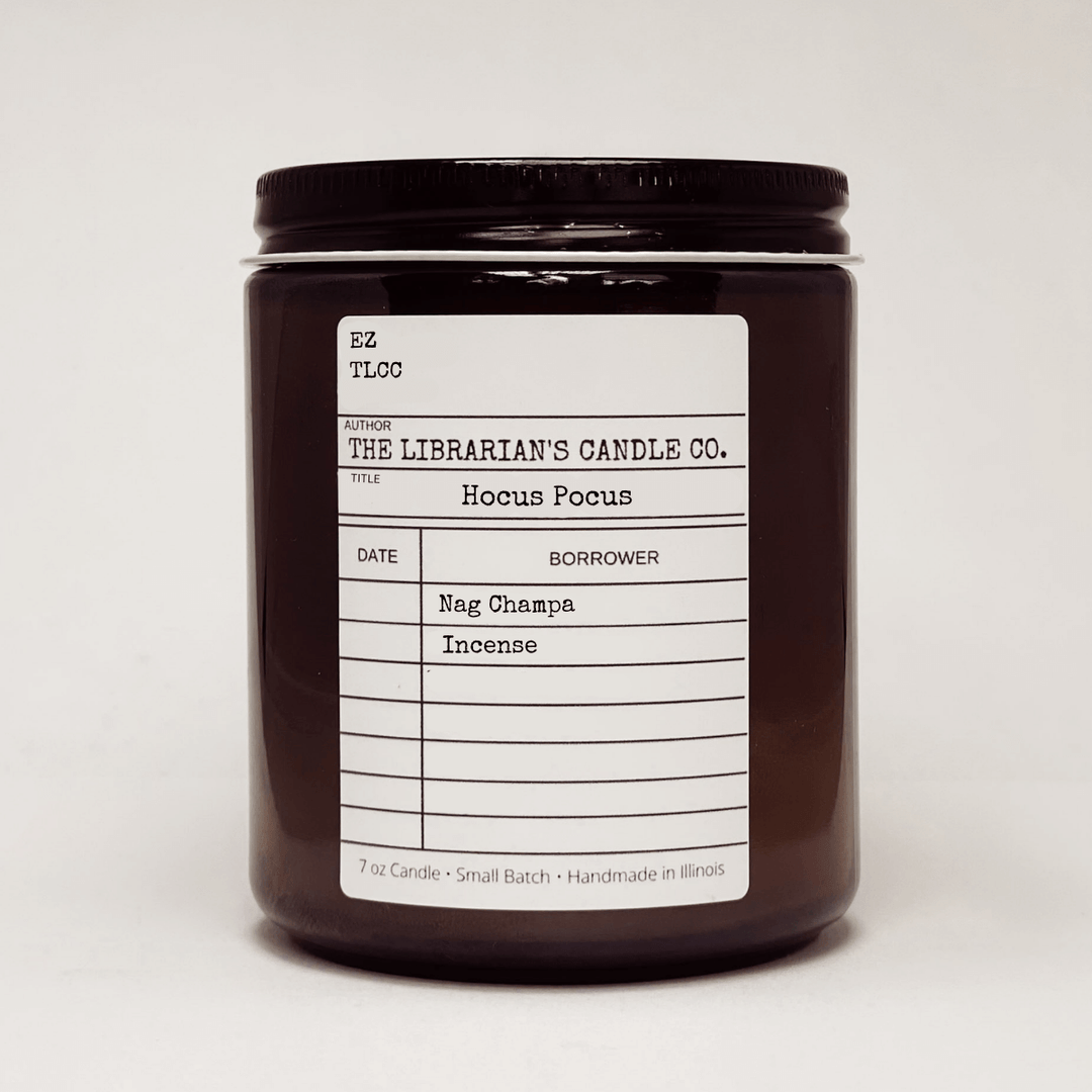 Hocus Pocus Scented Candle: Nag Champa & Incense in a brown glass jar with library card label.