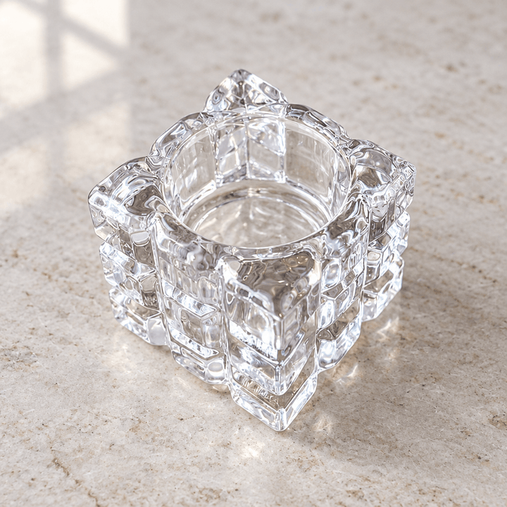 Close view of clear textured glass cube tealight holder and its round recessed opening.