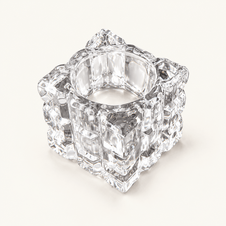 Empty clear glass cube tealight holder with an ice-like textured surface on ivory.