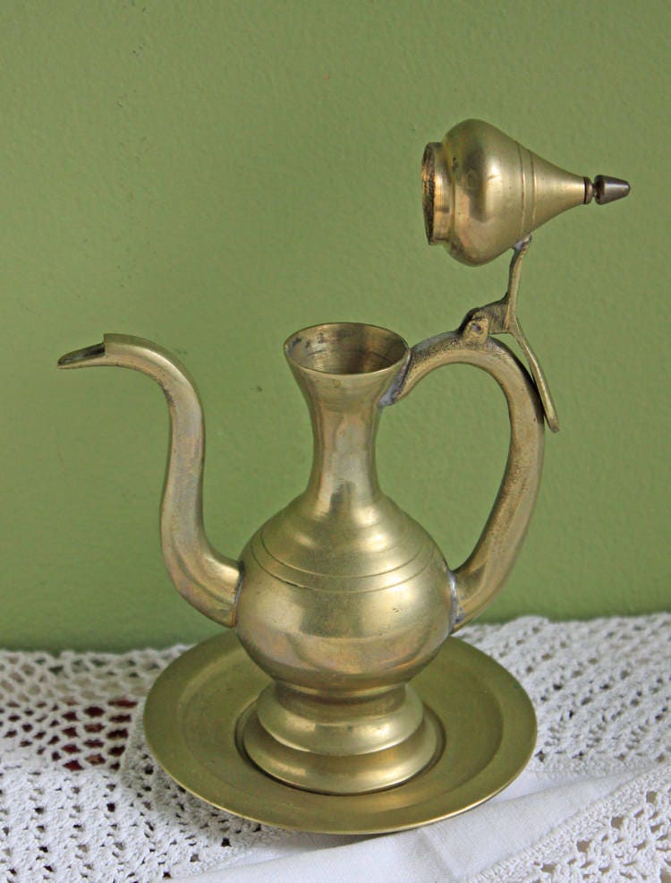 Vintage Brass Pitcher with Hinged Lid and Plate displayed on a table, showcasing its elegant design and condition.
