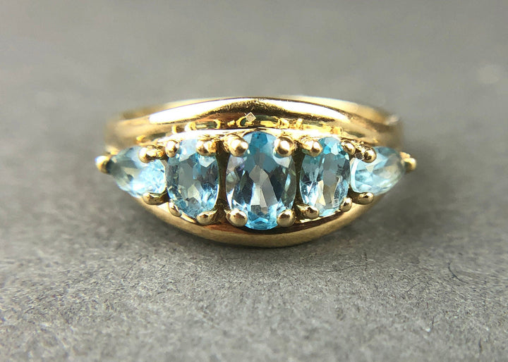 Vintage 10k Gold Ring with 5 Blue Topaz Stones featuring five oval blue topaz gems on a gold band.