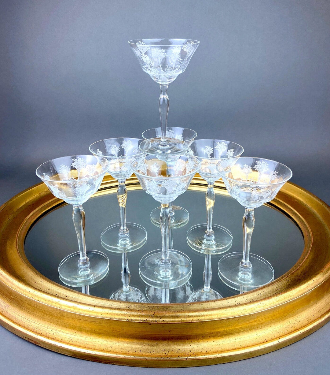 Vintage Morgantown Mayfair Etched Liquor Stemware, Set of 8 displayed on a mirror with a gold frame.