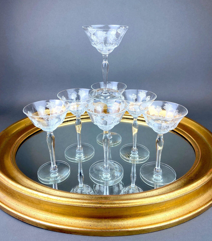 Vintage Morgantown Mayfair Etched Liquor Stemware, Set of 8 displayed on a mirror with a gold frame.