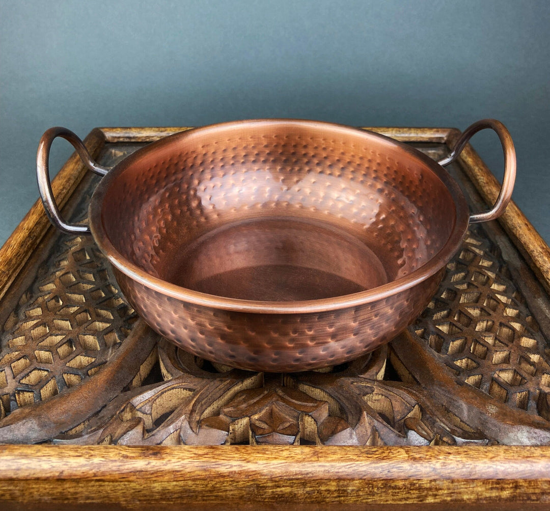 Vintage Hand Hammered Copper Bowl with Handles for Rustic Kitchen Decor on wooden tray