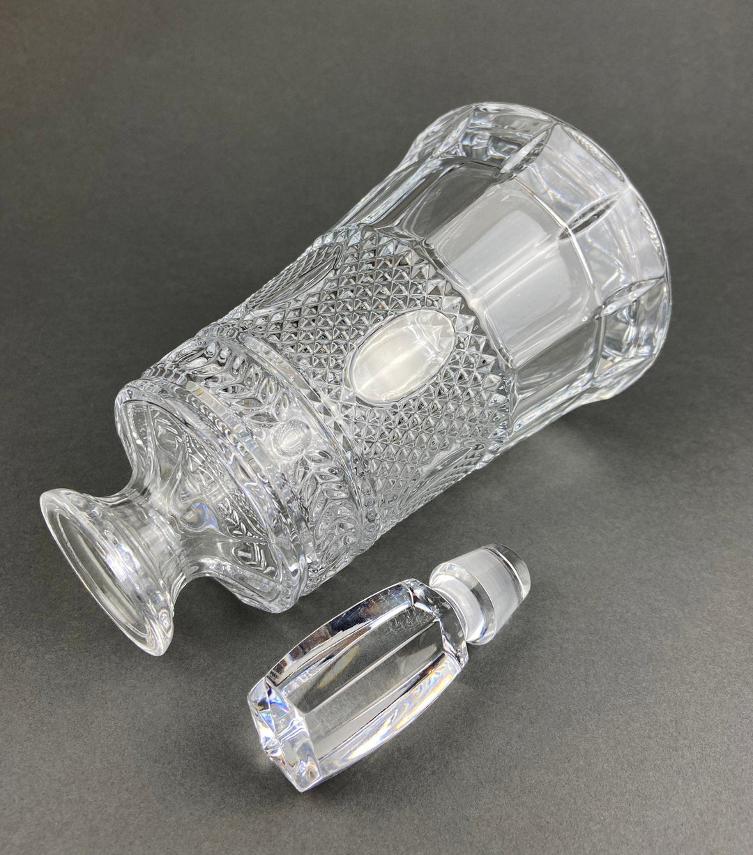 Crystal Decanter with Stopper. Cut Crystal Carafe on a dark background, showcasing intricate design details.