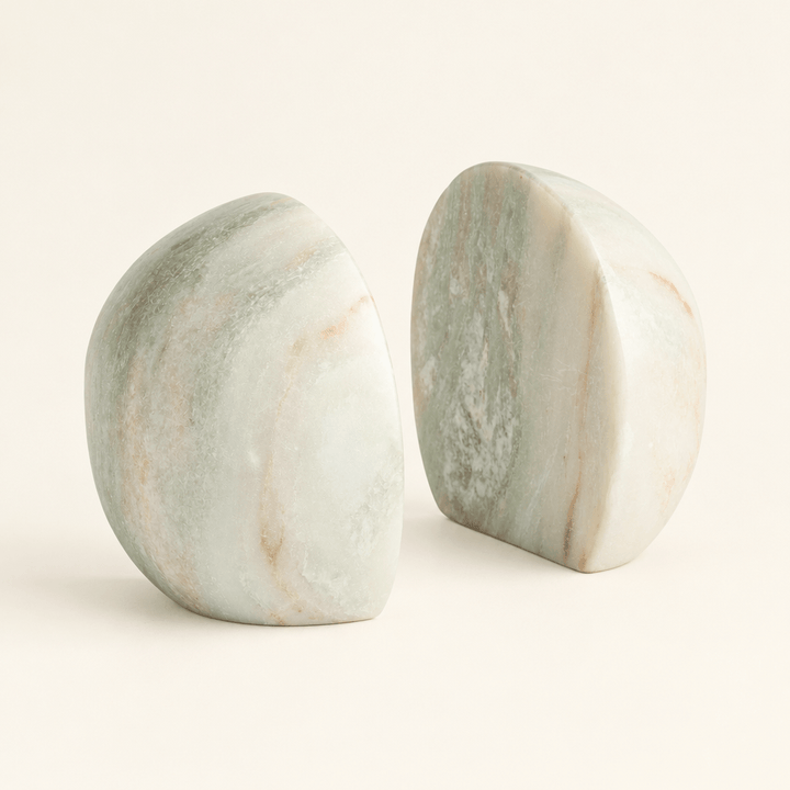 Pair of rounded green and white marble bookends with subtle natural veining on an ivory background.