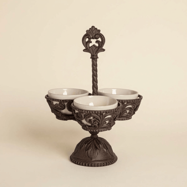 Bellavita Stoneware Condiment Server with three cream bowls and ornate dark metal pedestal on an ivory background.