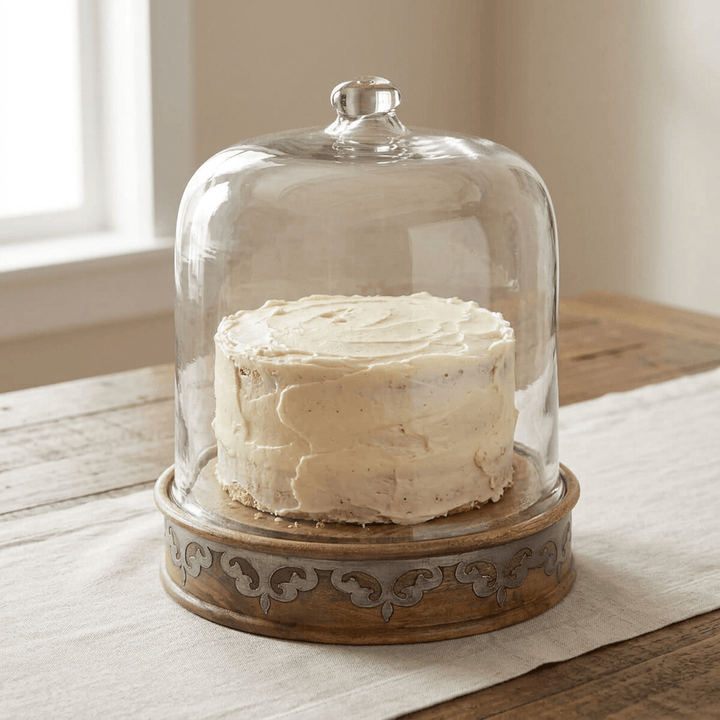 Belvedere Cake Keeper with Glass Dome displaying a buttercream cake on a wood dining table.
