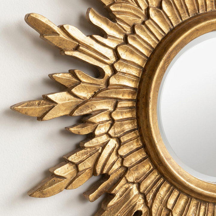Close-up of the Celeste Gold Sunburst Wall Mirror showing layered hand-carved wood rays and the Light Antique Gold finish.