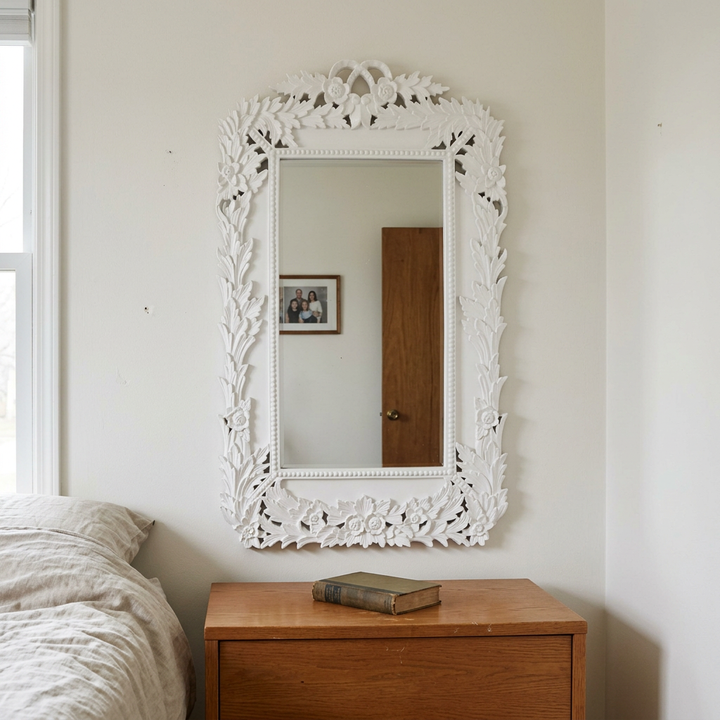 White Chantilly laurel wall mirror above an oak dresser in a simple bedroom