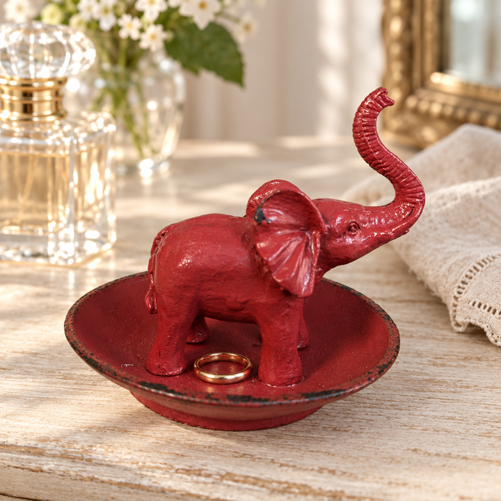 Antique Red Pewter Elephant Ring Dish holding a ring on a dressing table
