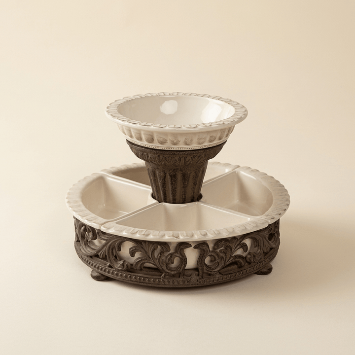 Bellavita cream stoneware chip and dip set with raised bowl and ornate dark brown metal base on an ivory backdrop