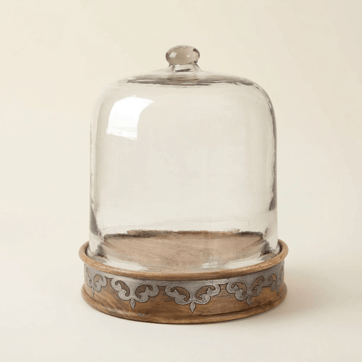 Belvedere Cake Keeper with Glass Dome showing mango wood and silver-tone scrollwork on an ivory background.