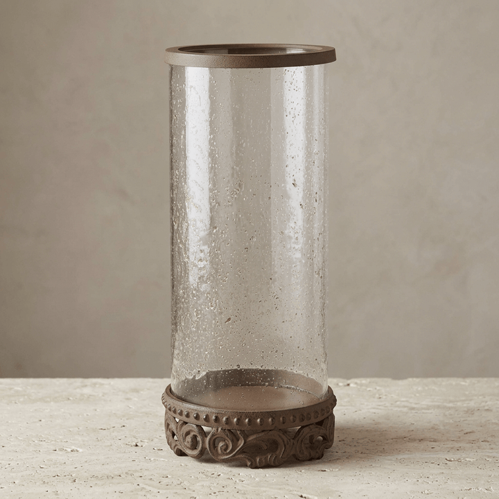 Tall Bellavita Glass Hurricane Candle Holder on a pale stone surface with a neutral studio backdrop.